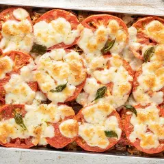 Fette di pomodoro gratinate con mozzarella filante e basilico, un piatto appetitoso con tanti cibi con la "a".