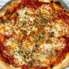 Pizza con impasto lievitato a regola d'arte, condita con pomodoro, mozzarella filante e capperi. Un'autentica delizia da pizzeria professionale.