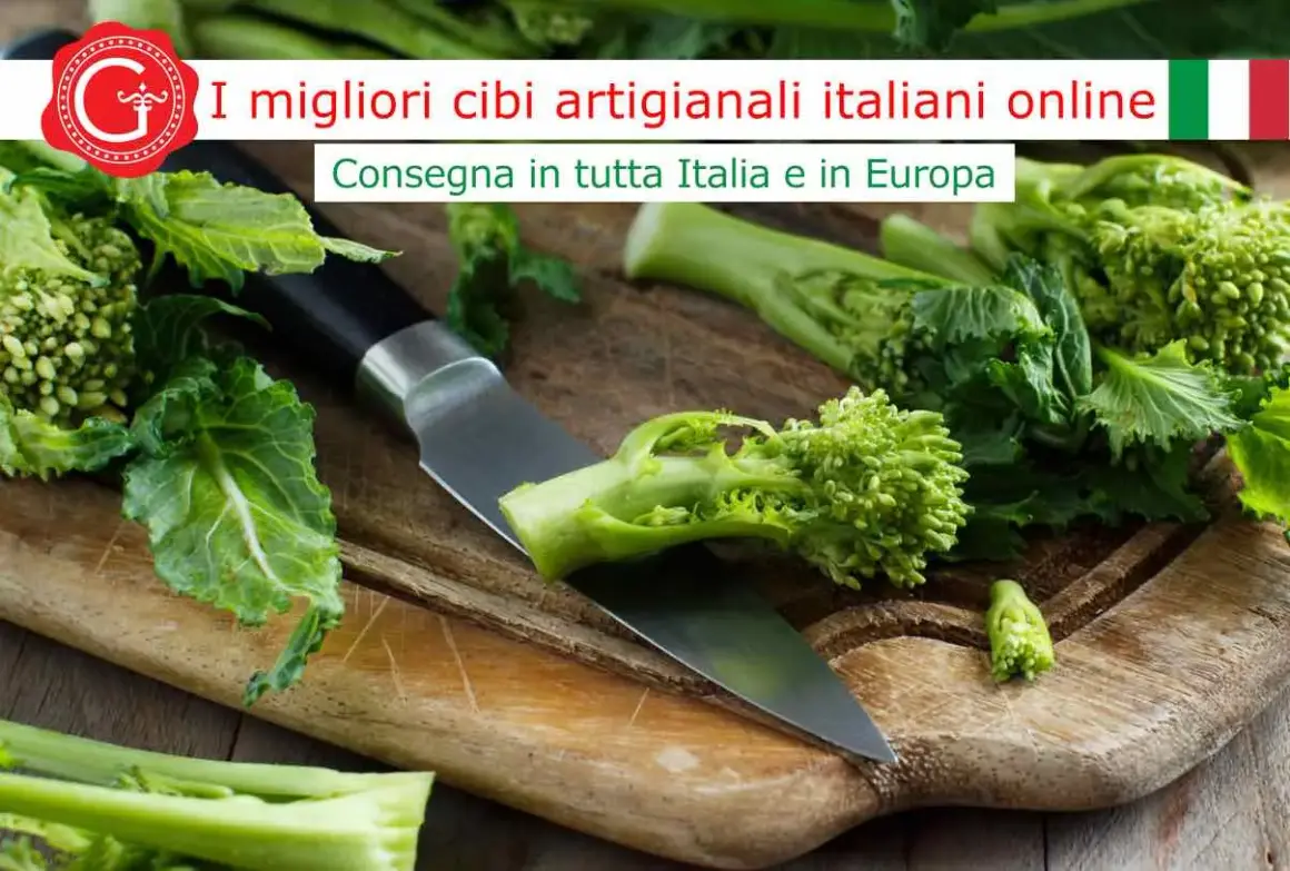 Cime di rapa fresche su un tagliere di legno, pronte per essere cucinate. La scritta "I migliori cibi artigianali italiani online" suggerisce la loro provenienza.