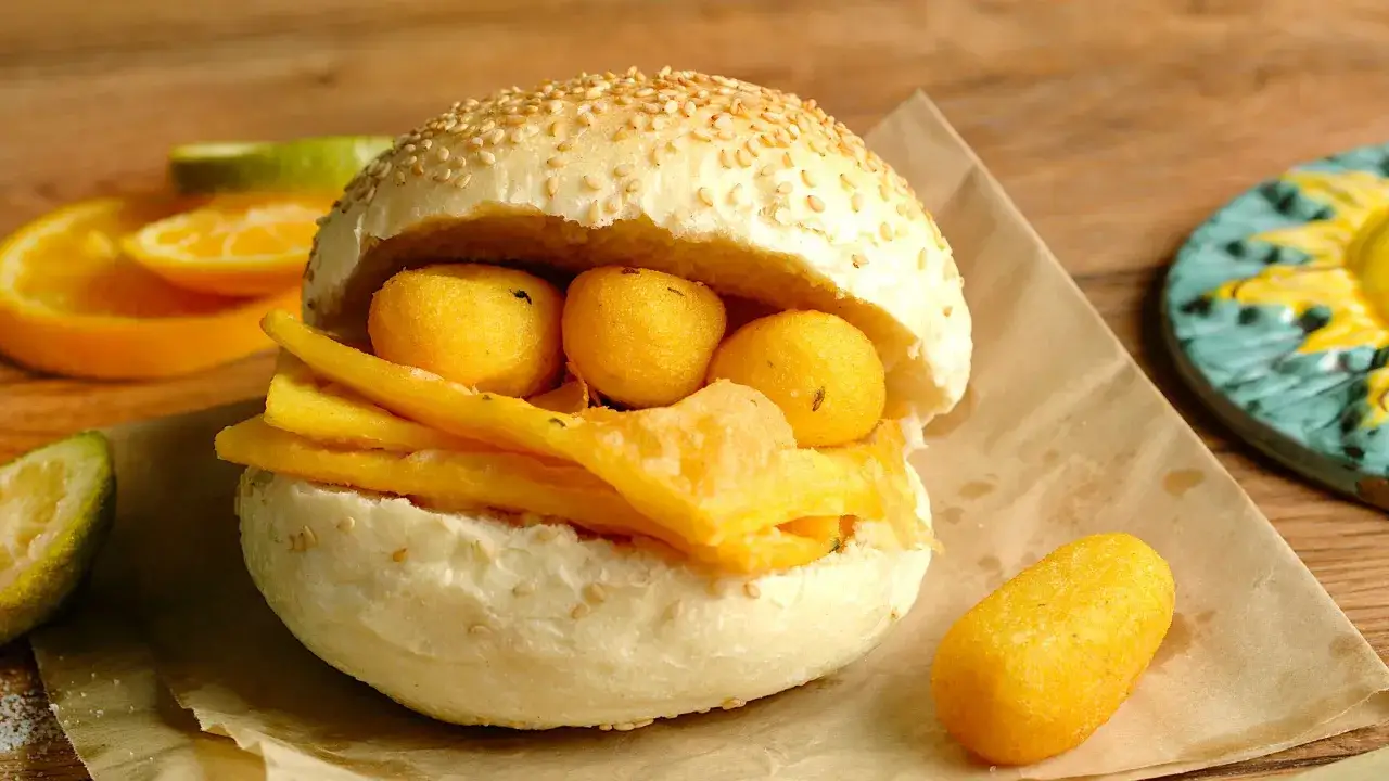 Pane e panelle, un panino goloso con panelle fritte e crocchette di patate, pronto per essere gustato.