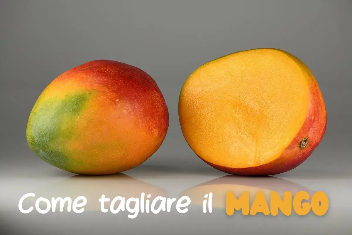 Un mango intero e uno tagliato a metà, mostrando la polpa succosa. Impara come si mangia il mango per gustarlo al meglio.